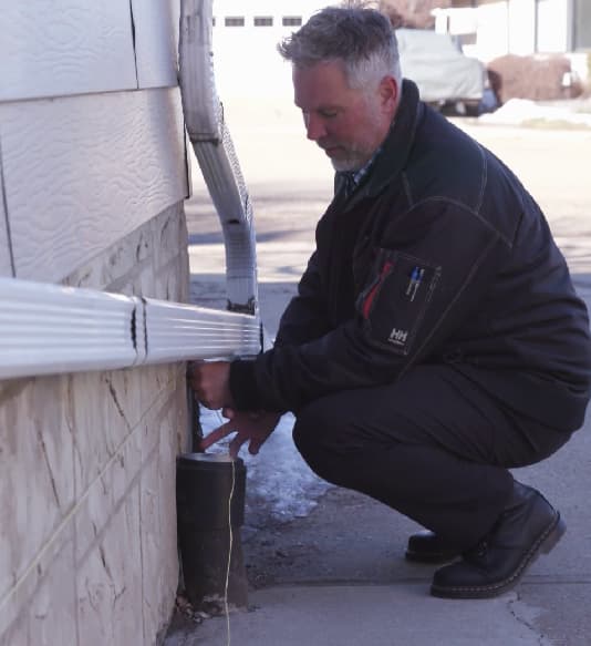 Image of a Shield foundation specialist inspecting a home exterior for damage