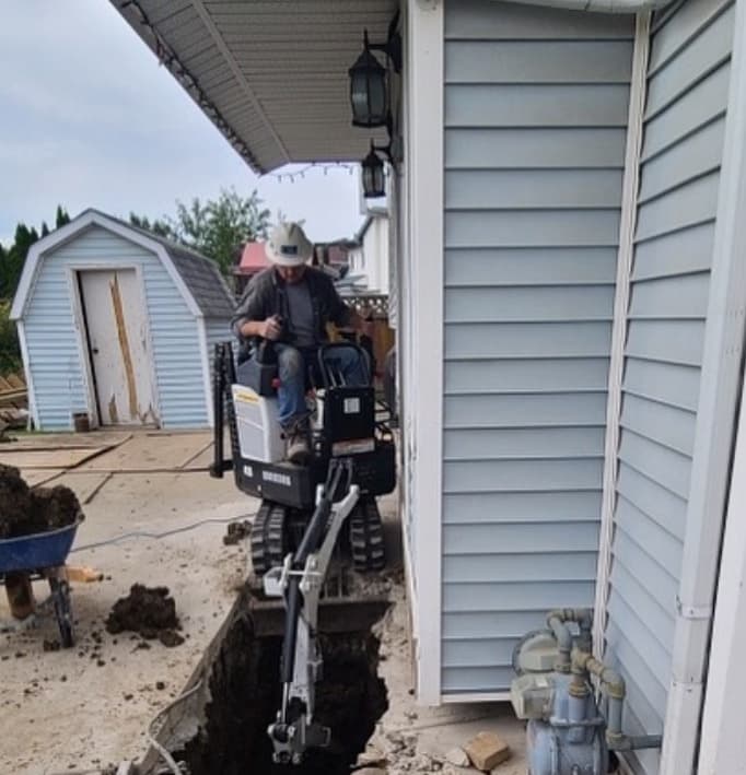 Image of digger digging around home foundation.