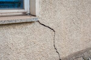 Exterior foundation crack extending from the corner of a window
